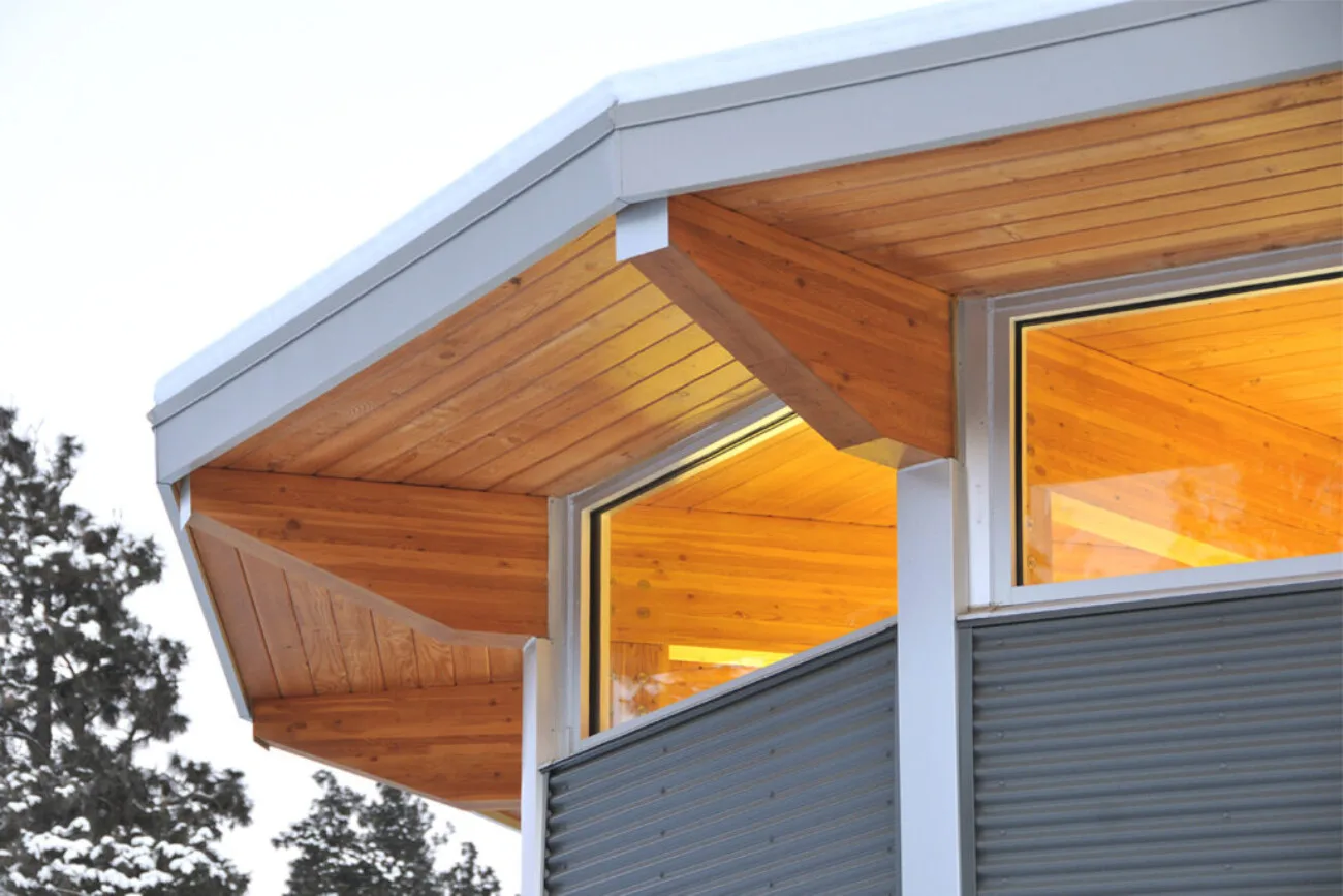 The timber-lined roof soffit projecting over a window.